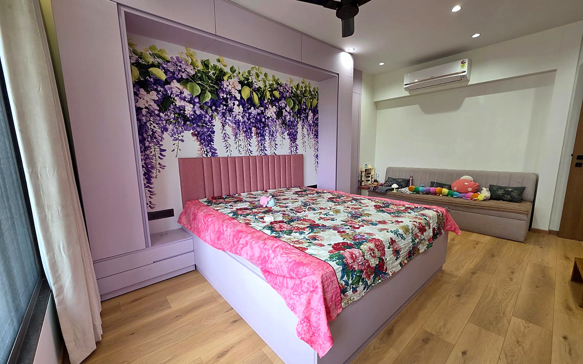 Complete bedroom interior by Royal Decor in Vesu, Surat — customised wallpaper, wooden flooring, upholstered bed backrest and curtains